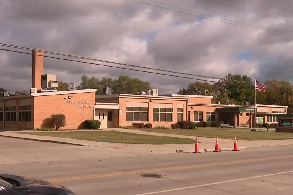 Pleasantview Elementary School building with an American flag and three orange cones in front.