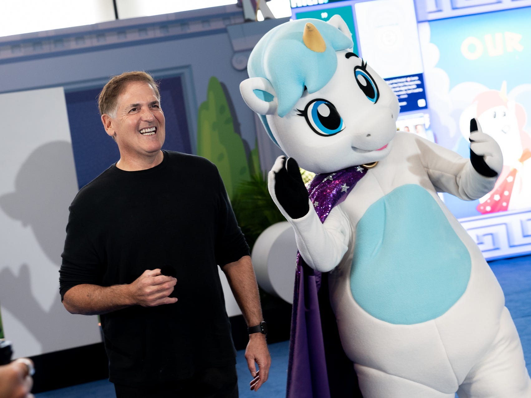 Mark Cuban poses next to HLTH's unicorn mascot.
