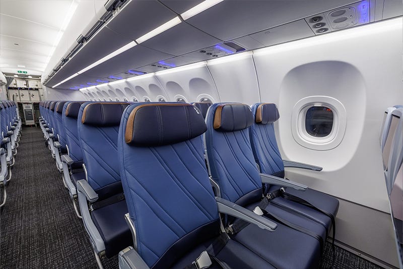 The economy cabin on AA's A321XLR. The seats are blue with brown around the headrests.