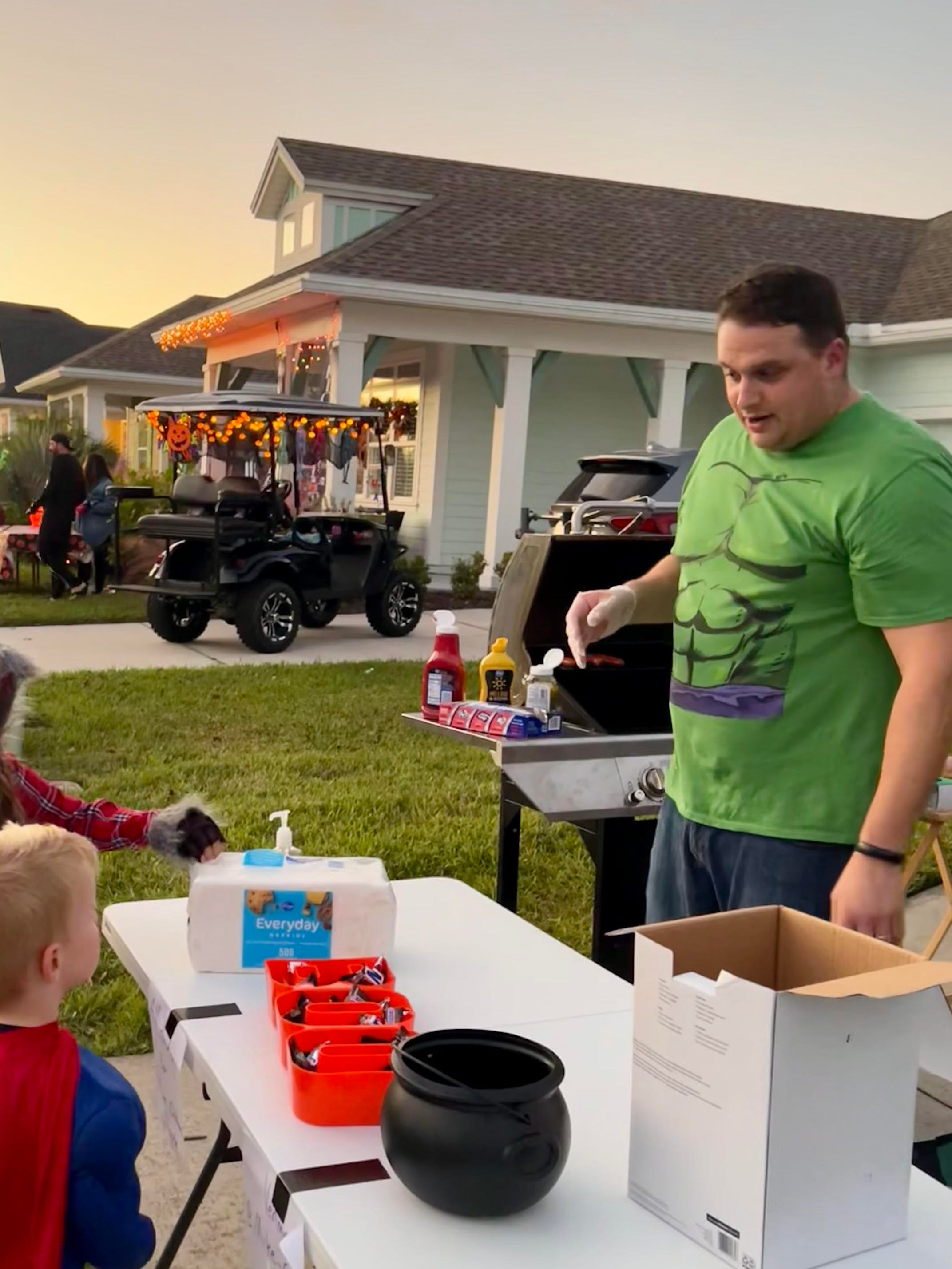 The author's husband makes hot dogs on Halloween to share with the neighborhood.