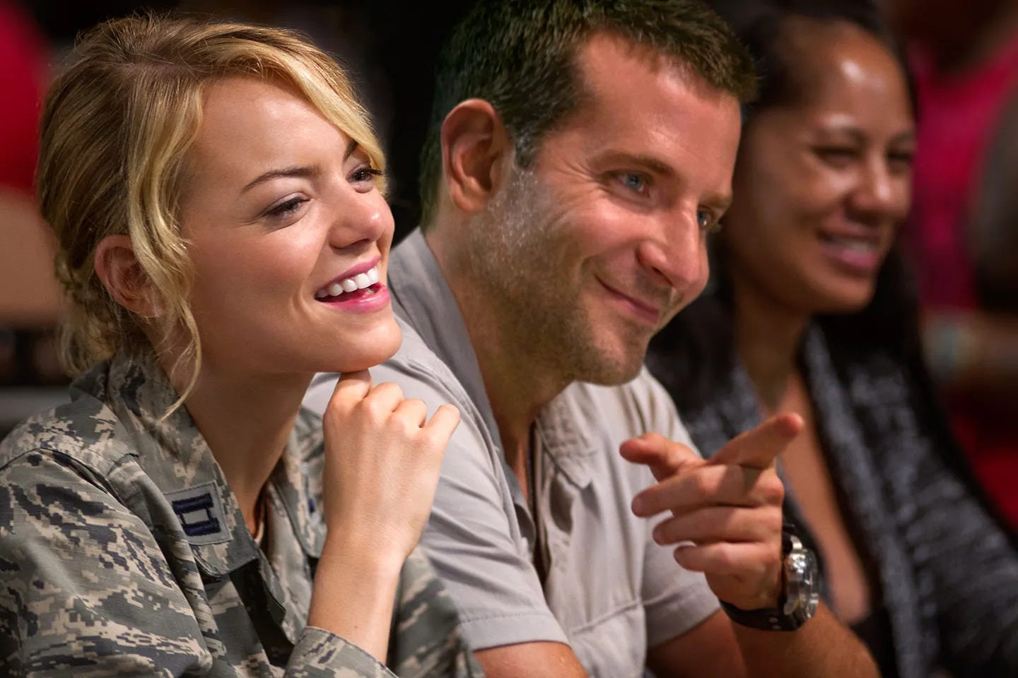 Emma Stone and Bradley Cooper smiling in the movie Aloha
