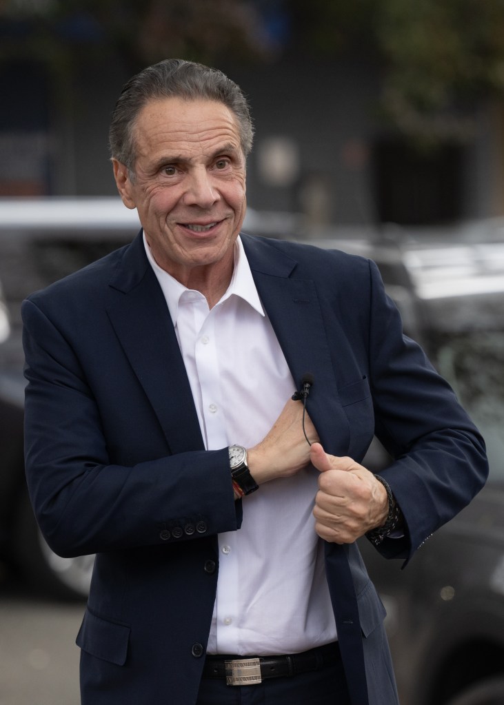 Andrew Cuomo adjusting a lapel mic.