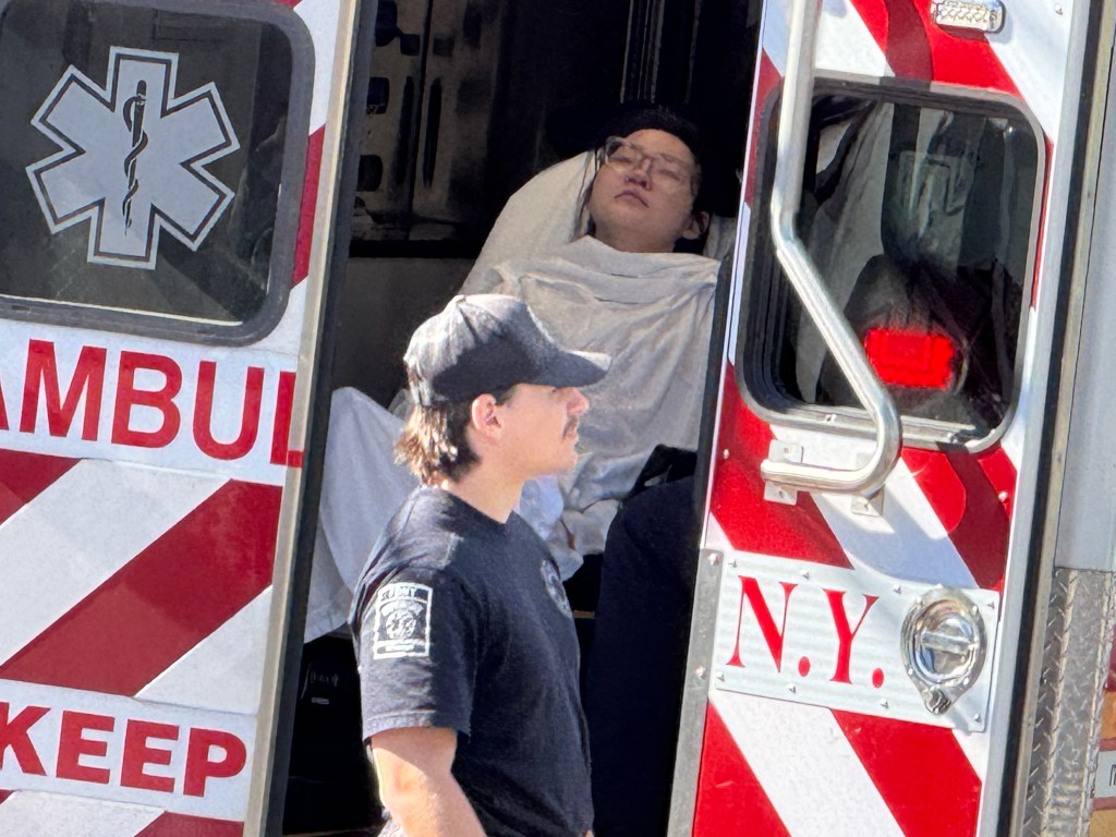 The 30-year-old woman lies in an ambulance before being transported to the hospital.