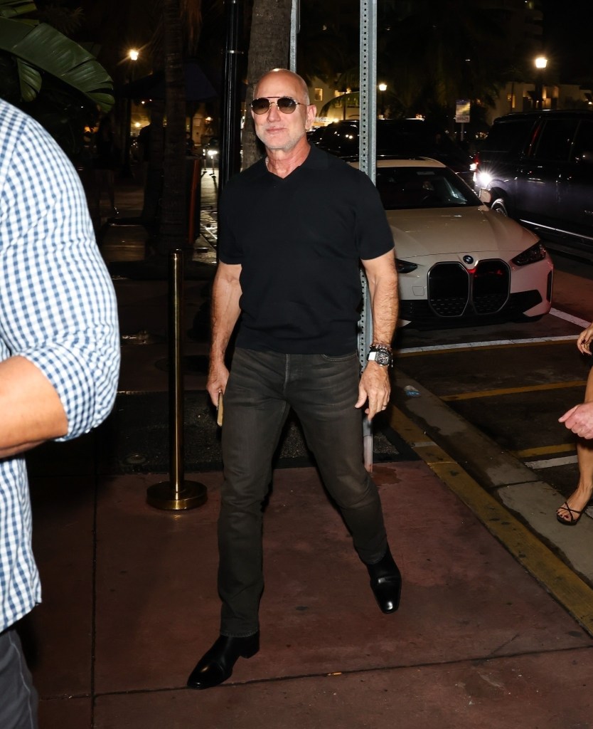 Jeff Bezos walking outdoors at night.