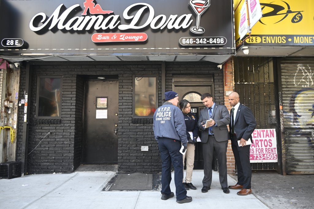 NYPD officers from the crime scene unit investigate a fatal stabbing outside Mama Dora Bar and Lounge.