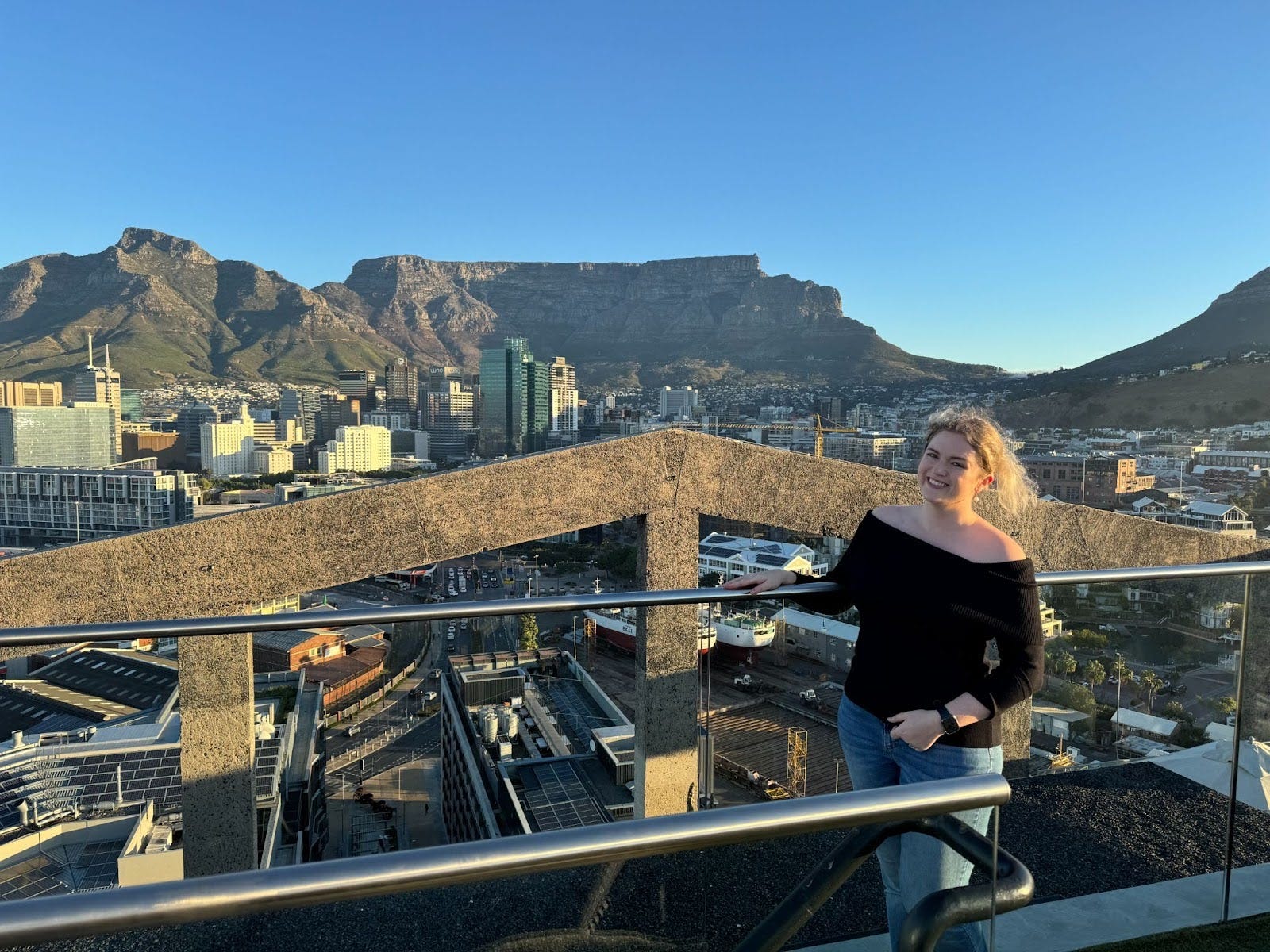 The author standing in front of a view of a city and mountains.