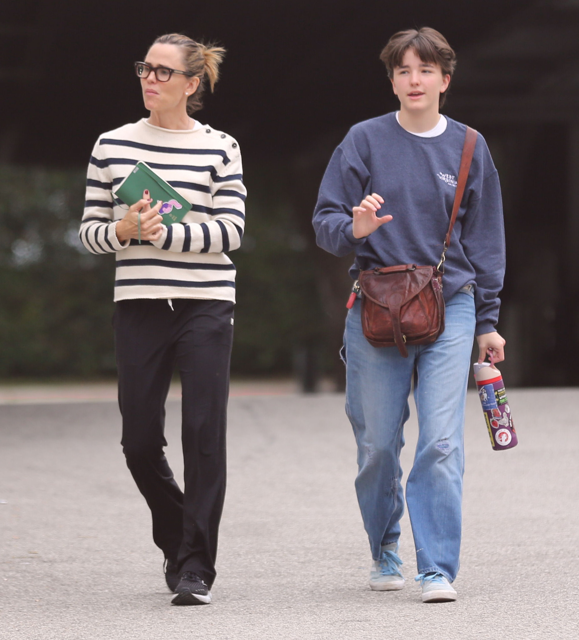 Jennifer Garner and her child walking outdoors.