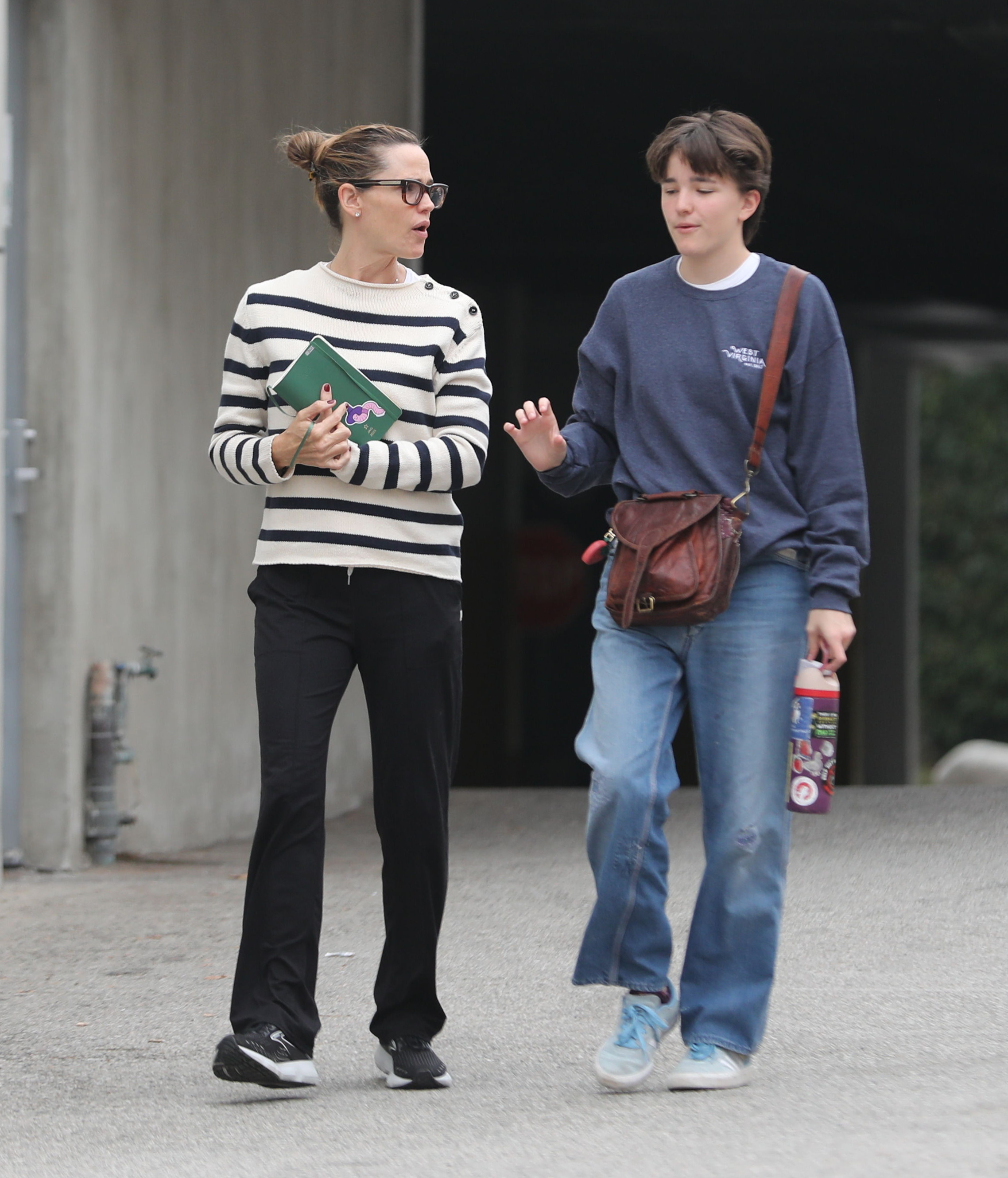 Jennifer Garner and her child walking outdoors.