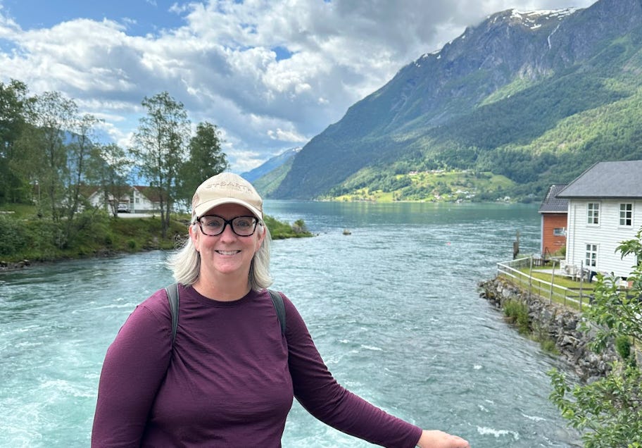 The writer posing in front of the water while on a solo trip in Europe.