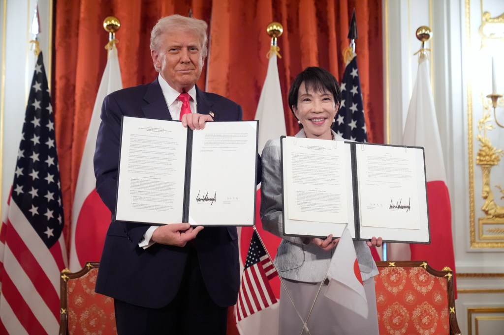 Donald Trump and Sanae Takaichi posing with documents at Akasaka Palace.