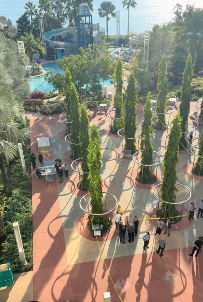 Aerial view of first responders and yellow police tape on a patio at a resort.