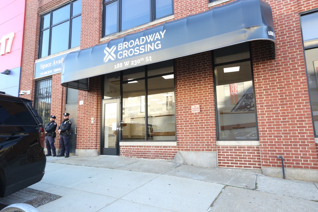 The Broadway Crossing building at 188 W 230th St in the Bronx, with two police officers standing outside.