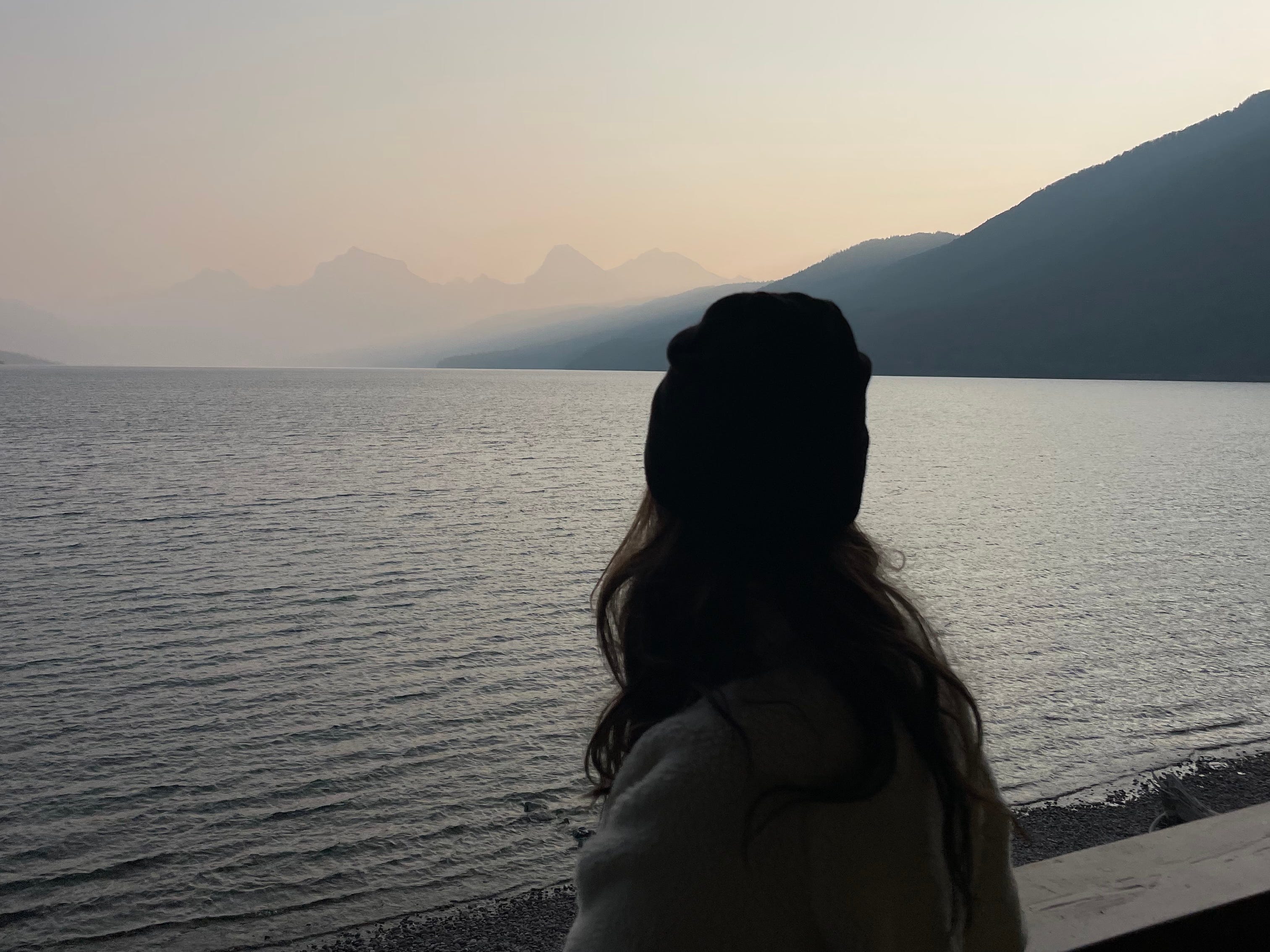 Woman looking out at a lake and mountains