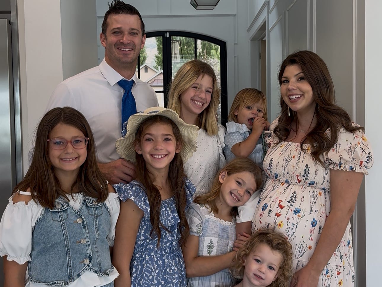 A family of eight, including a woman who is pregnant.