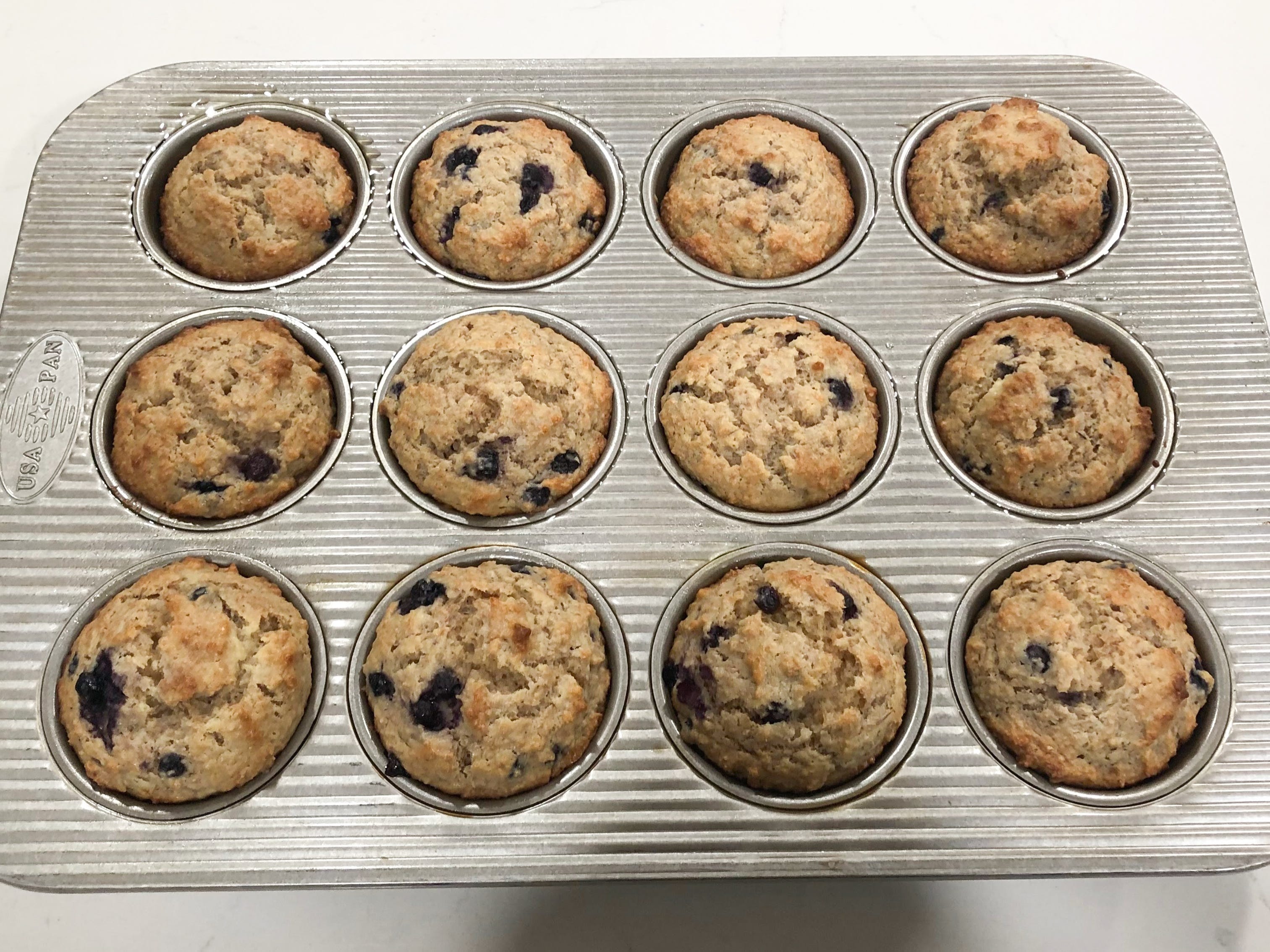 Cooked blueberry-bran muffins in a pan.
