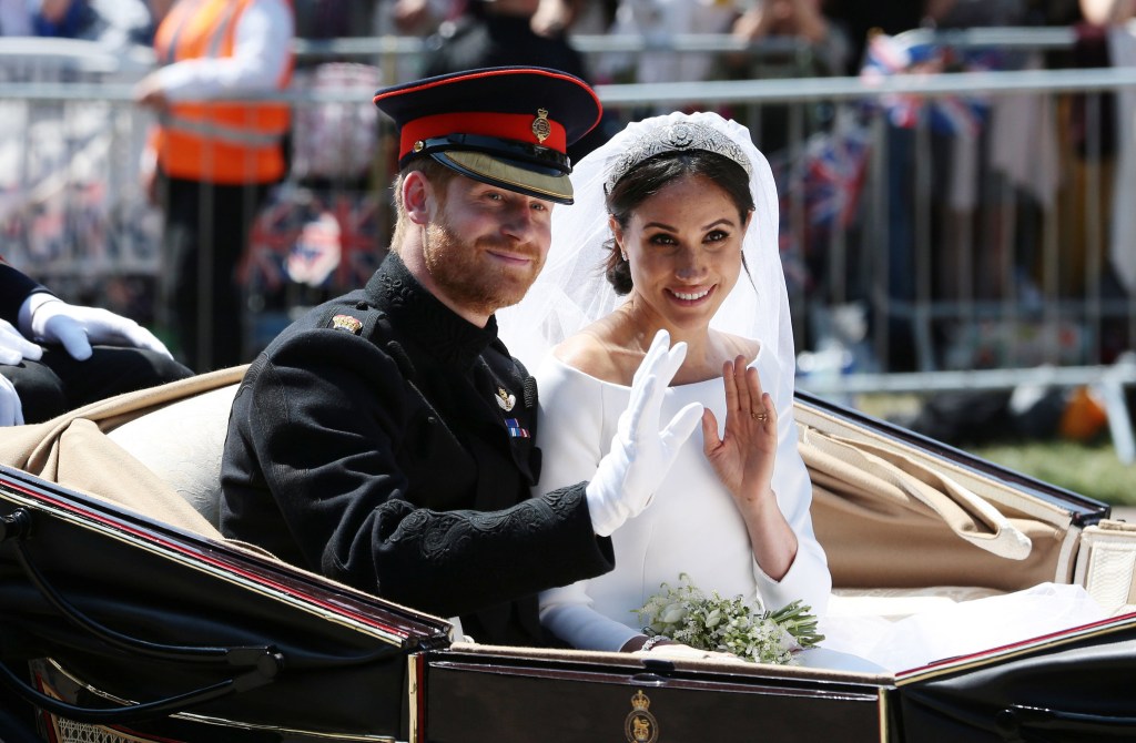 Prince Harry and Meghan Markle wave from a carriage during their wedding procession.
