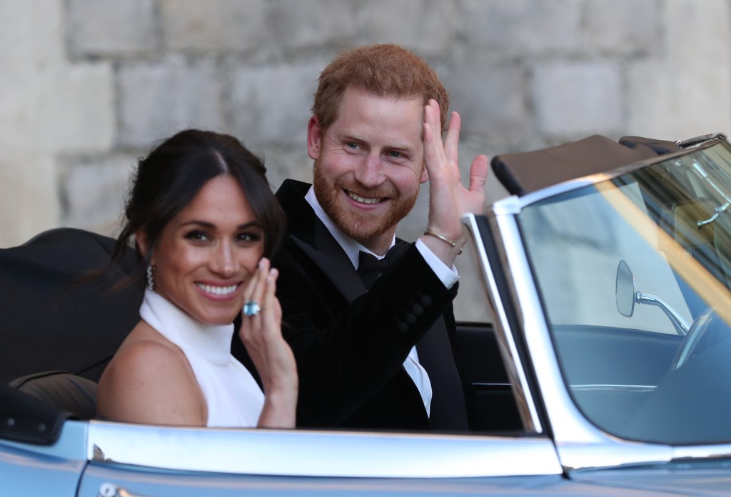 Duchess Meghan and Prince Harry wave from a car after their wedding.
