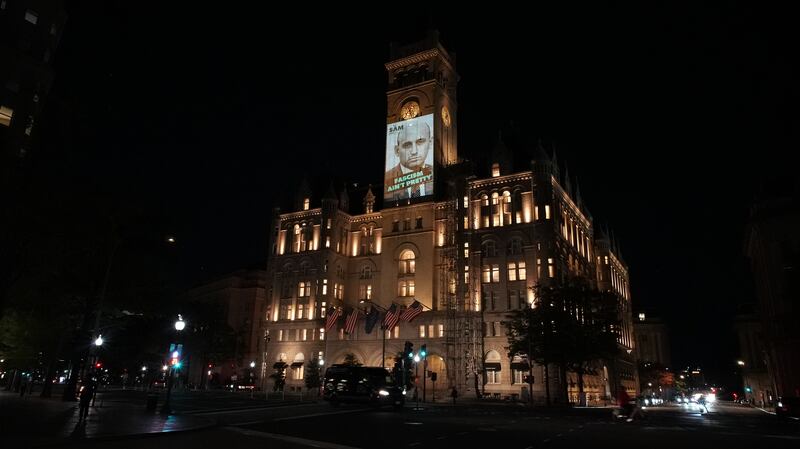 Stephen Miller's face is projected on the Old Post Office tower that was once the site of Trump International Hotel in Washington DC.
