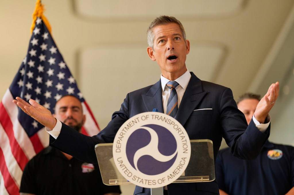 United States Secretary of Transportation Sean Duffy speaking at a podium with the Department of Transportation seal and an American flag in the background.