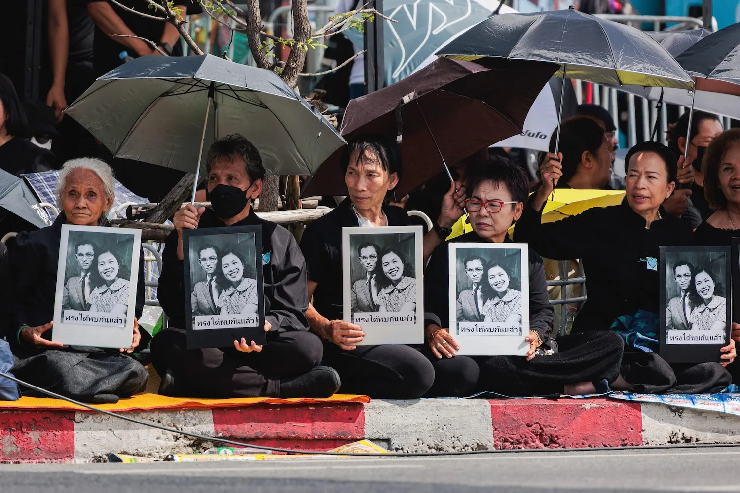 People are seen carrying portraits of King Bhumibol Adulyadej Rama IX, the previous king, and Queen Sirikit, the queen mother of King Maha Vajiralongkorn, during the royal procession in Bangkok, Thailand, on Oct. 26.