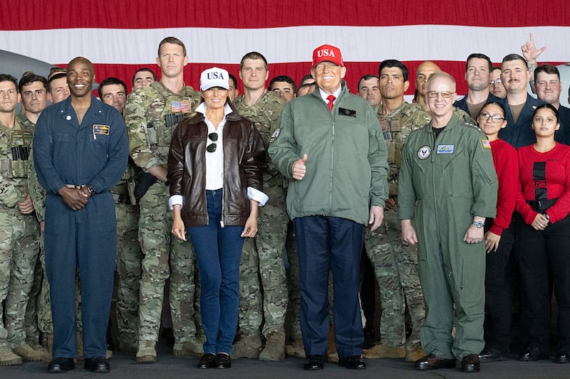 US President Donald Trump (C-R) and First Lady Melania Trump (C-L) pose as they greet sailors during a visit to the USS George H.W. Bush aircraft carrier which is out at sea near Norfolk, Virginia, October 5, 2025, as part of the US Navy's 250th anniversary celebration,