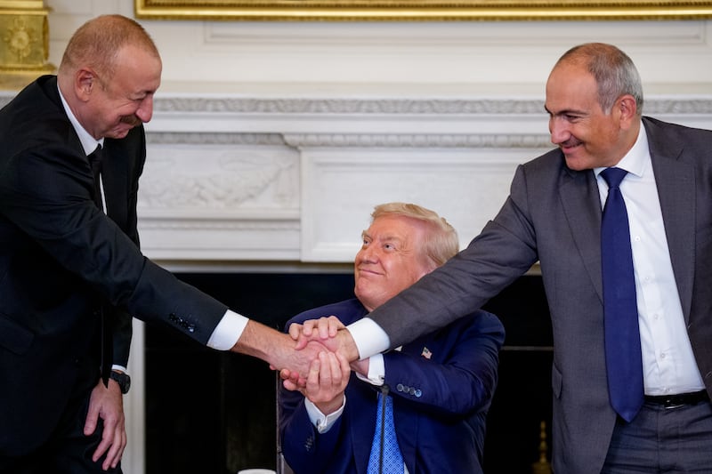President Donald Trump (C) joins hands with Azerbaijani President Ilham Aliyev (L) and Armenian Prime Minister Nikol Pashinyan (R) during a signing ceremony in the State Dining Room of the White House on August 8, 2025 in Washington, DC. Trump brought the two leaders together in an initial attempt to end the conflict between Armenia and Azerbaijan that has lasted for decades. (Photo by Andrew Harnik/Getty Images)