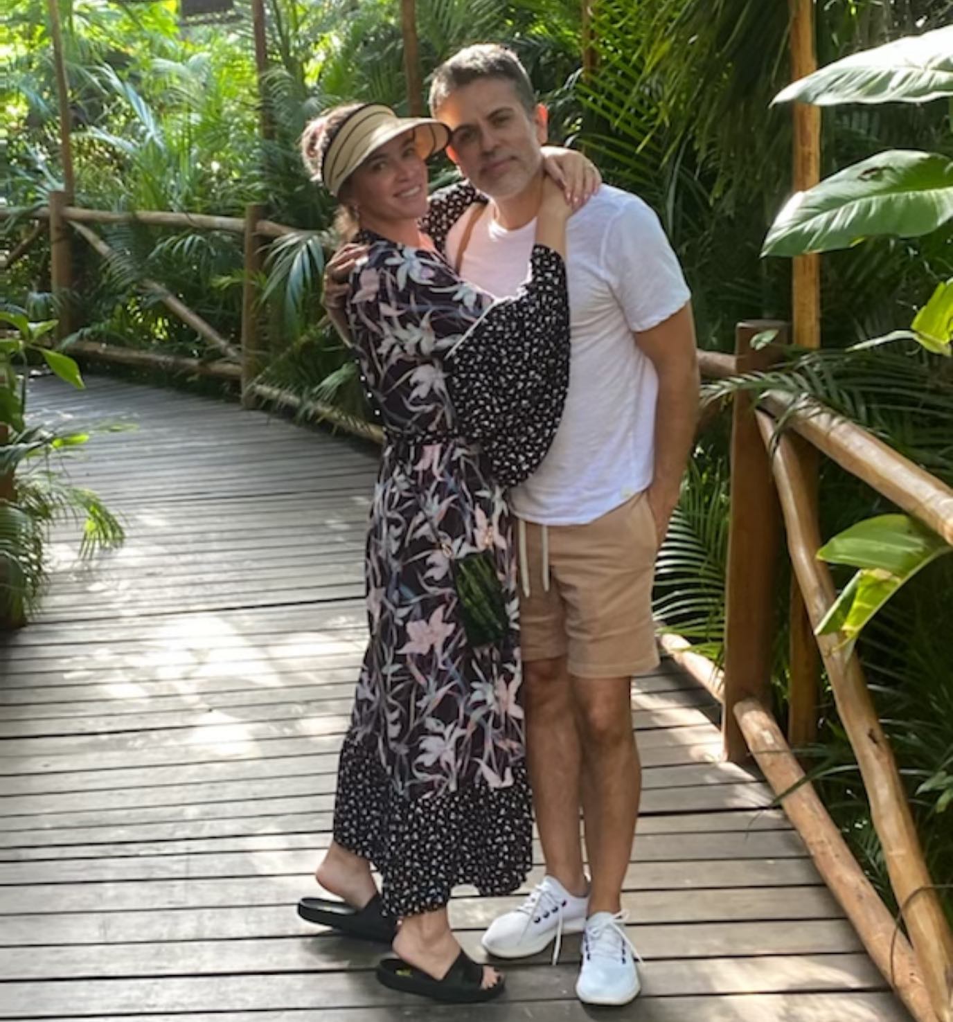 Teddi Mellencamp and Edwin Arroyave embracing on a wooden walkway.