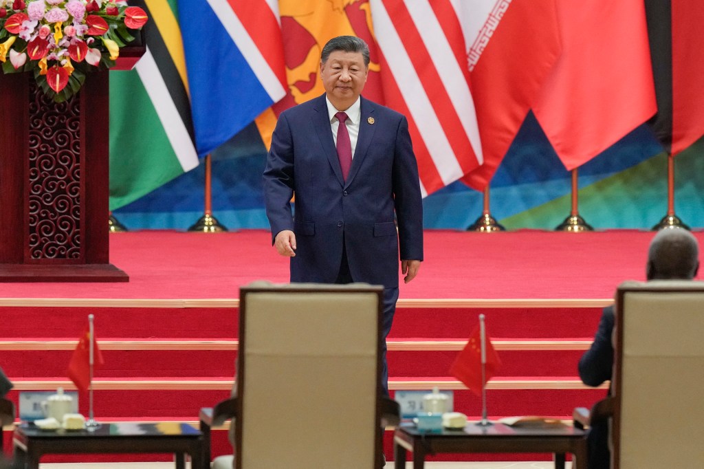 China's President Xi Jinping returning to his seat after delivering a speech at the Global Women's Summit in Beijing.