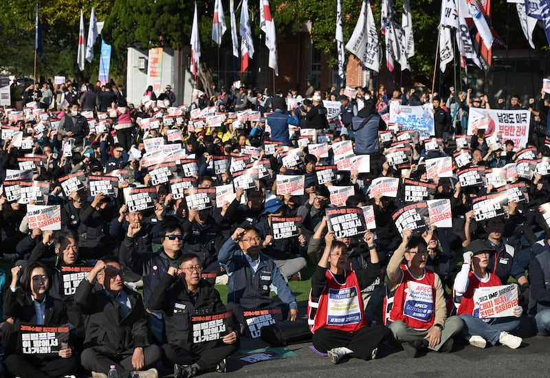 South Korean protesters shout slogans and hold placards during a rally against US President Trump on October 29, 2025.