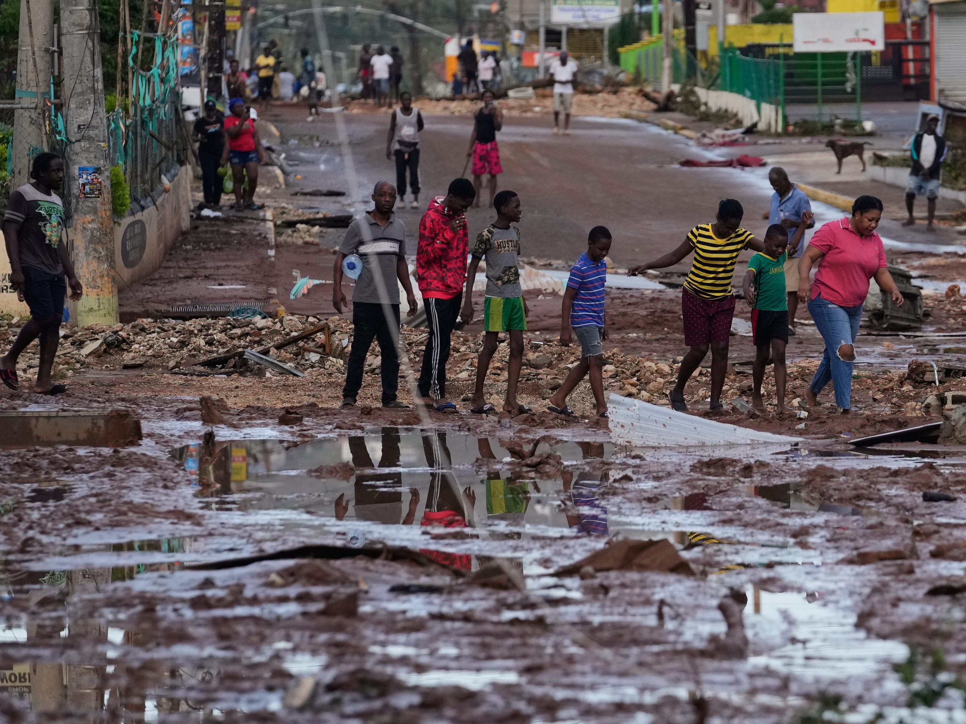 Residents walk through Santa Cruz, Jamaica, Wednesday, Oct. 29, 2025, after Hurricane Melissa passed.