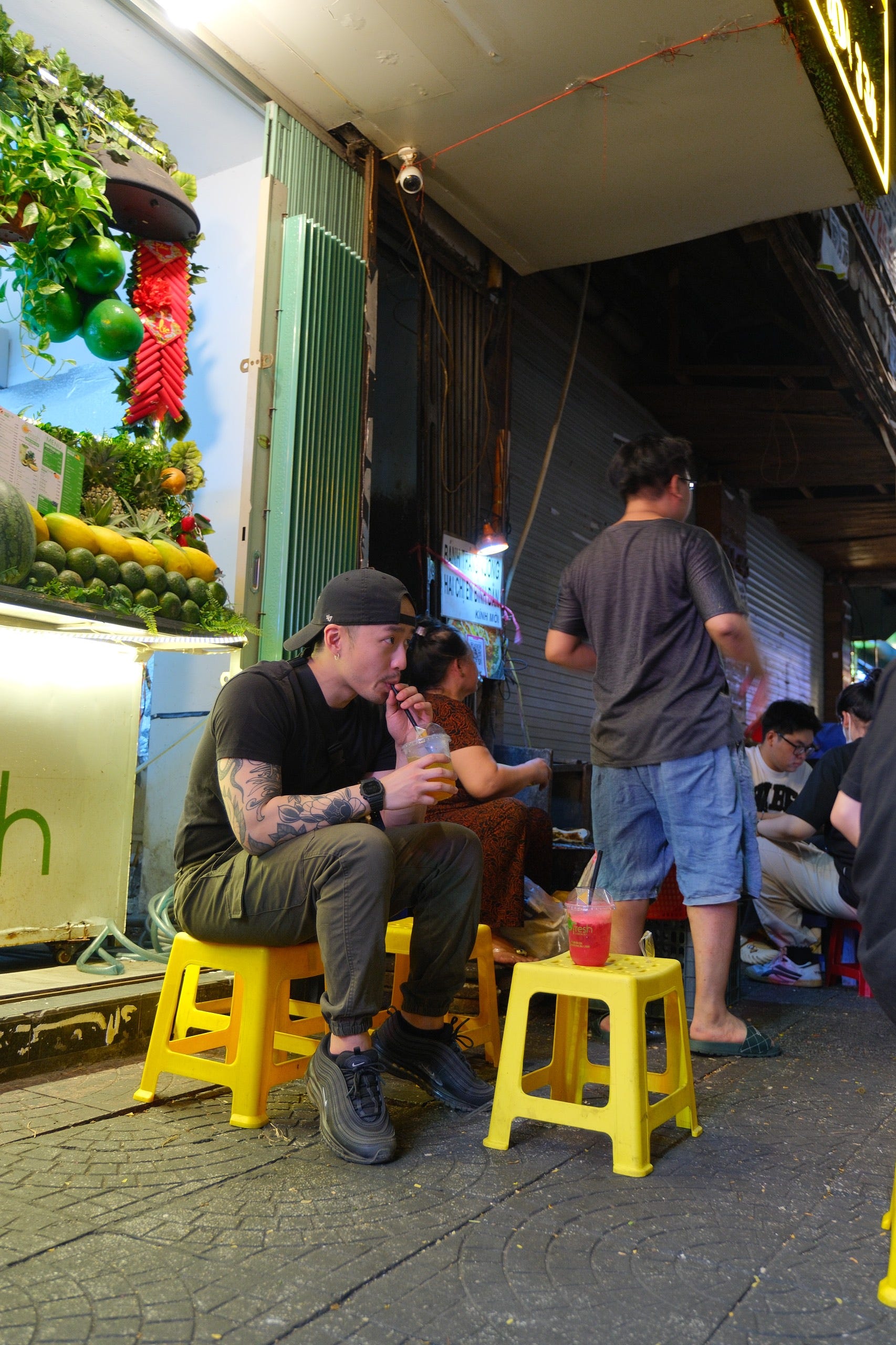 A man sitting down at at roadside stall in Vietnam.