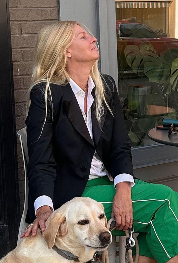 Barbara Molnar petting a dog while sitting on a chair.