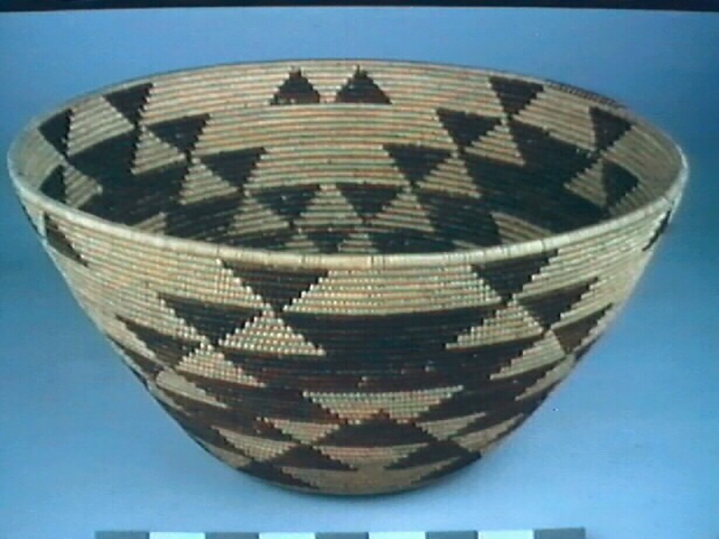 Woven basket with black and tan triangular patterns.