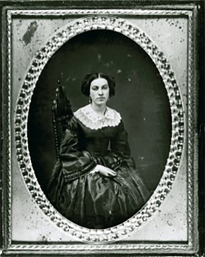 Portrait of a seated woman in a dark dress with a white lace collar.