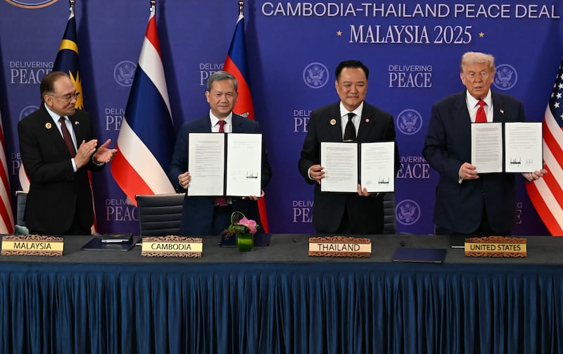 (From L t R) Malaysia's Prime Minister Anwar Ibrahim applauds as Cambodia's Prime Minister Hun Manet, Thailand's Prime Minister Anutin Charnvirakul and US President Donald Trump hold up documents during the ceremonial signing of a ceasefire agreement between Thailand and Cambodia on the sidelines of the 47th Association of Southeast Asian Nations (ASEAN) Summit in Kuala Lumpur on October 26, 2025. (Photo by MOHD RASFAN / POOL / AFP) (Photo by MOHD RASFAN/POOL/AFP via Getty Images)