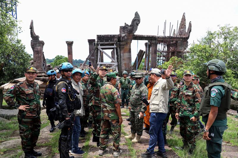 This pool photo taken and released on August 20, 2025 by Agence Kampuchea Presse (AKP) shows Cambodian and foreign military personnel speaking during a visit organized by Cambodia's Ministry of Defence following the CambodiaThailand border conflict at the Preah Vihear temple in Preah Vihear province. A long-running border row between the Southeast Asian neighbours boiled over into conflict in July involving artillery bombardments, air strikes and infantry clashes, killing at least 43 people and forcing more than 300,000 others to flee their homes. (Photo by POOL / AFP) (Photo by STR/POOL/AFP via Getty Images)