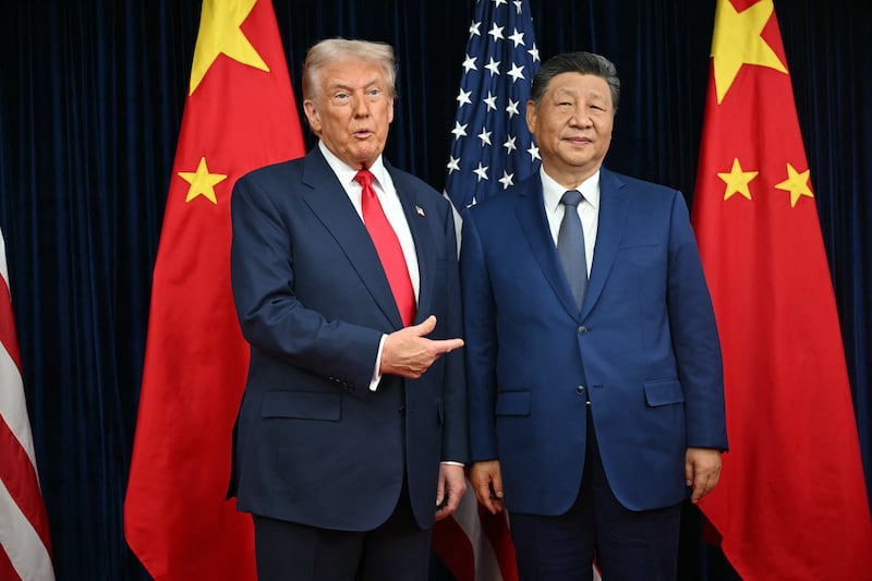 TOPSHOT - US President Donald Trump (L) and China's President Xi Jinping greet each other as they arrive for talks at the Gimhae Air Base, located next to the Gimhae International Airport in Busan on October 30, 2025. Donald Trump and Chinese leader Xi Jinping will seek a truce in their bruising trade war on October 30, with the US president predicting a 