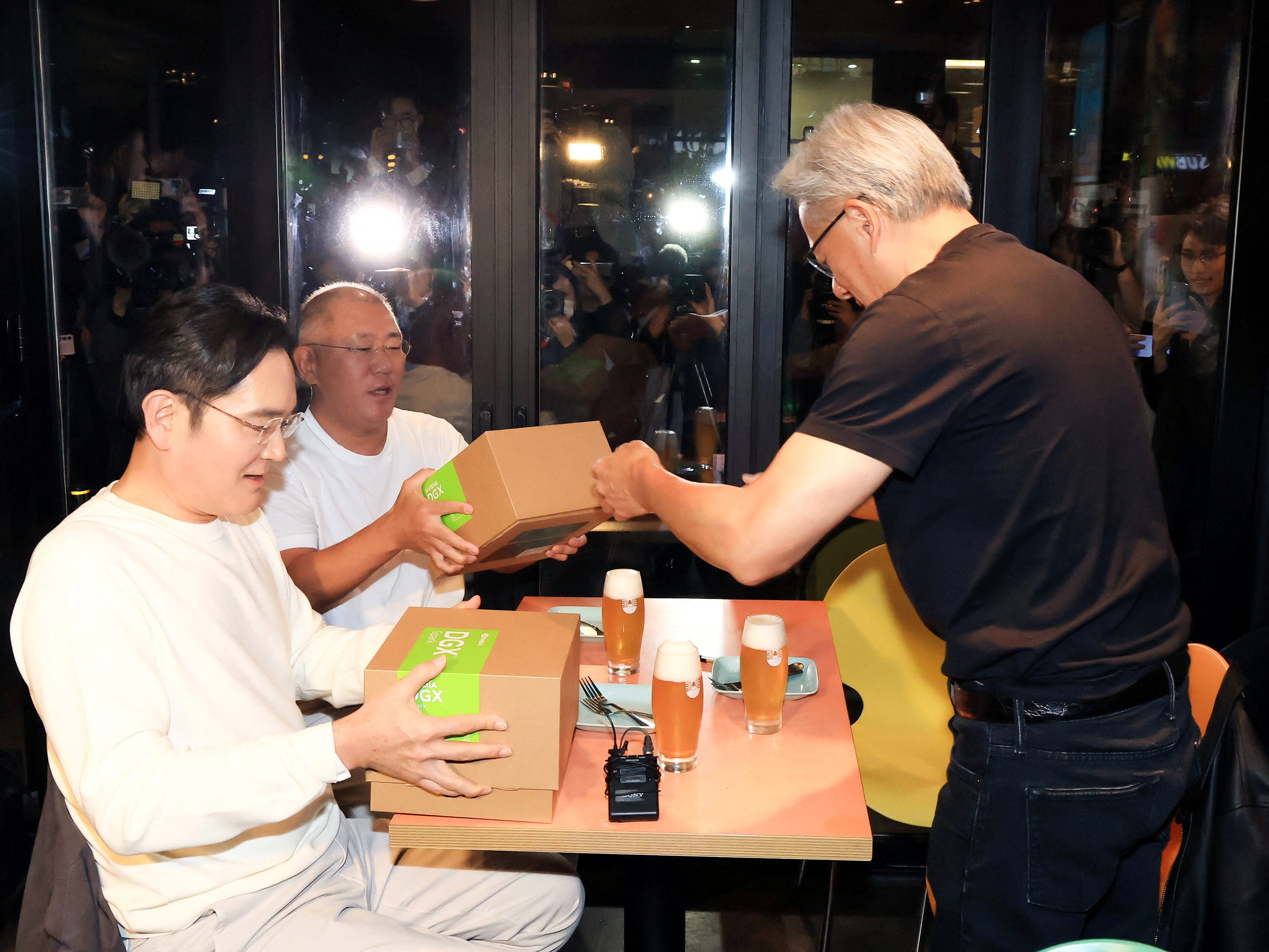 Jensen Huang gives gift boxes to the chief executives of Samsung and Hyundai.