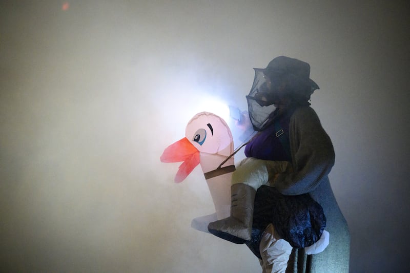 An anti-I.C.E. protester in an inflatable costume stands in a cloud of tear gas near the U.S. Immigration and Customs Enforcement building