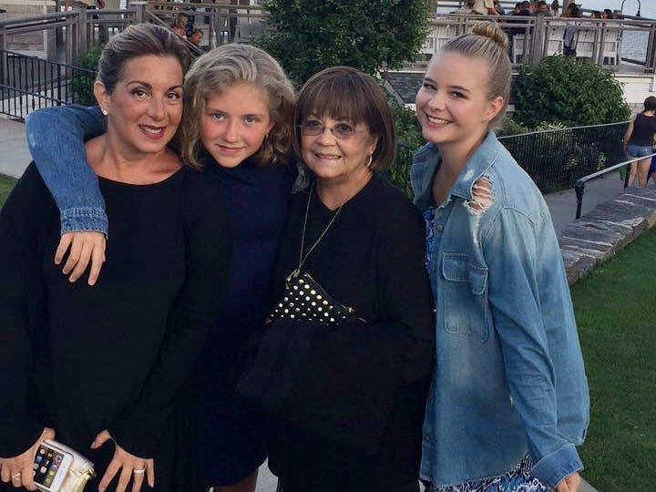 Two older women stand in a restaurant with their daughters and granddaughters