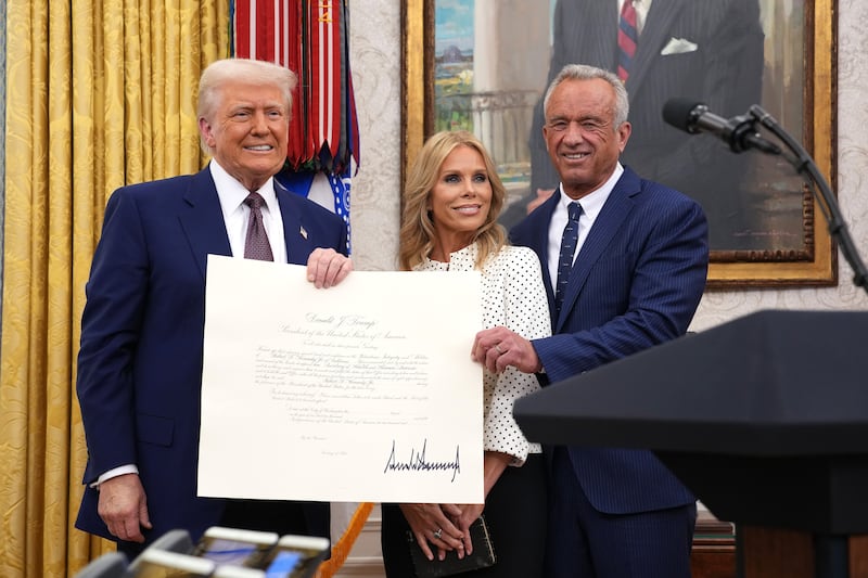 U.S. President Donald Trump, Robert F. Kennedy Jr., and Kennedy's wife Cheryl Hines pose after Kennedy was sworn in as Secretary of Health and Human Services in the Oval Office at the White House on February 13, 2025 in Washington, D.C.