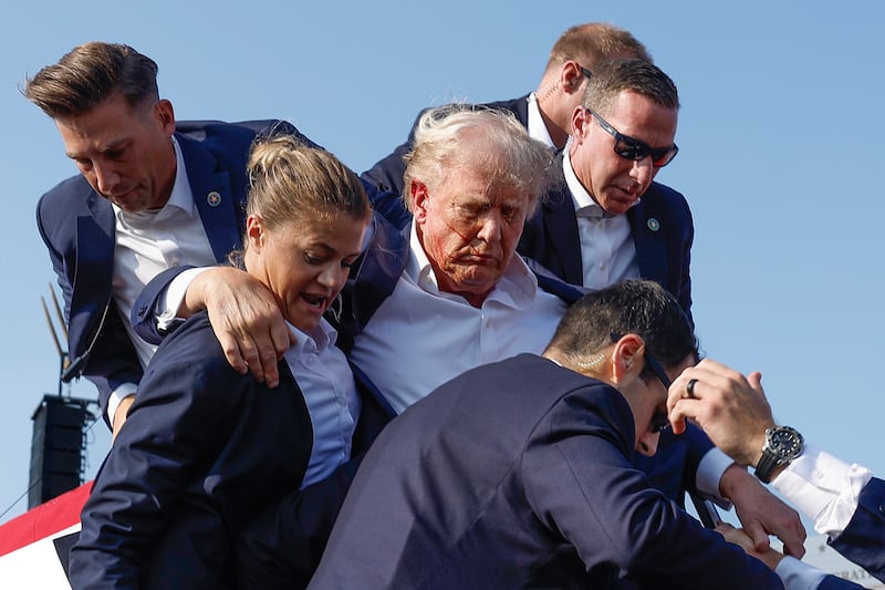BUTLER, PENNSYLVANIA - JULY 13: Republican presidential candidate former President Donald Trump is rushed offstage by U.S. Secret Service agents after being grazed by a bullet during a rally on July 13, 2024 in Butler, Pennsylvania. Butler County district attorney Richard Goldinger said the shooter is dead after injuring former U.S. President Donald Trump, killing one audience member and injuring another in the shooting. (Photo by Anna Moneymaker/Getty Images)
