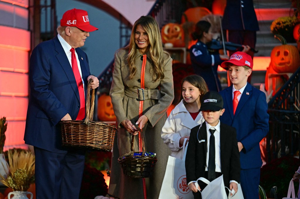US President Donald Trump and US First Lady Melania Trump greet kids dressed as US President Donald Trump and US First Lady Melania Trump with a Secret Service officer, as they host a Halloween event at the White House in Washington, DC on OCtober 30, 2025. (Photo by Jim WATSON / AFP) (Photo by JIM WATSON/AFP via Getty Images)