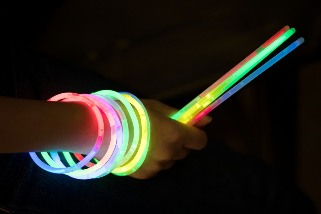 A person holds several glowsticks.