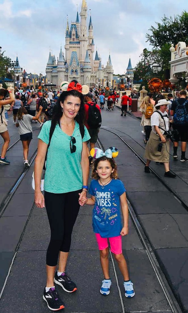 Liz Healy and a child holding hands at Disney World.