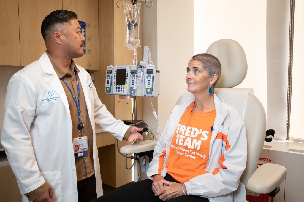 Nurse Joseph Bacani explains infusion to patient Liz Healy in a treatment room at Memorial Sloan Kettering.