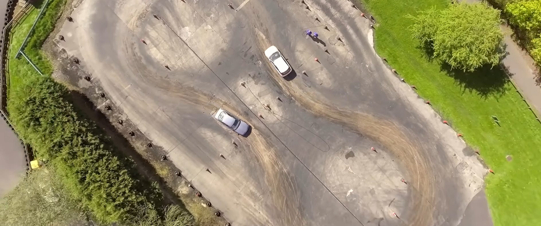 Ariel shot of two cars on a tarining ground for skidpan driving.
