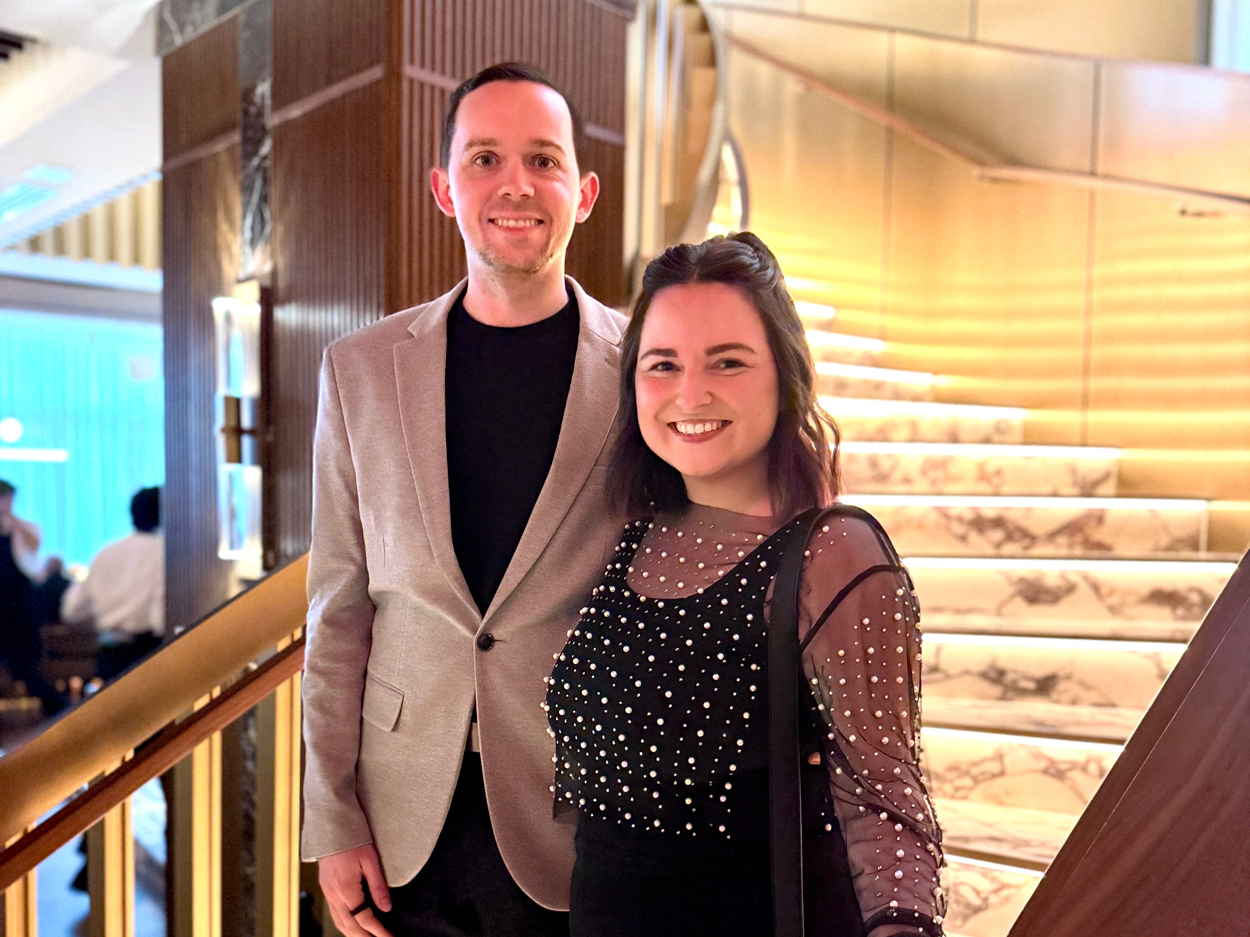 Author Kelsey Huson and man standing on marble steps at 1587 Prime, smiling
