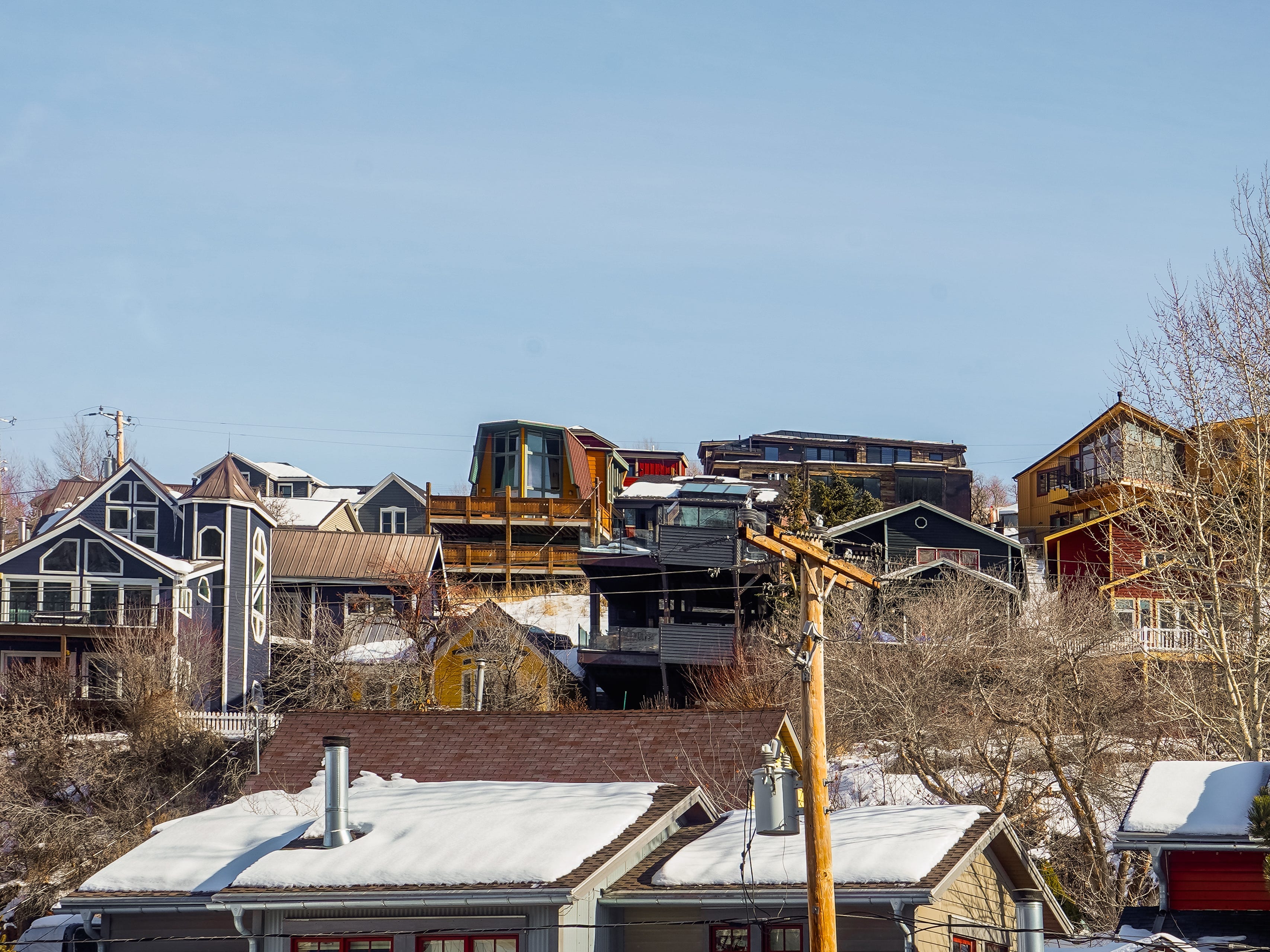 Layers of snow-topped luxury homes on a hill with clear skies