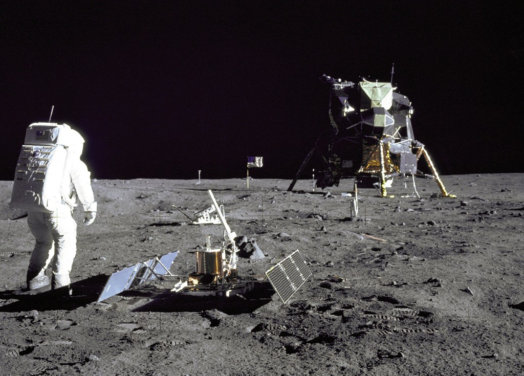 Astronaut Buzz Aldrin on the moon next to scientific equipment and the lunar module during the Apollo 11 mission.